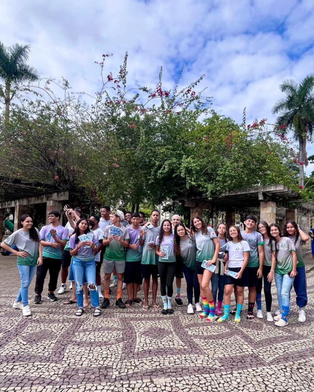 Foto de vários estudantes posando na praça da cidade, usando meias coloridas e diferentes
